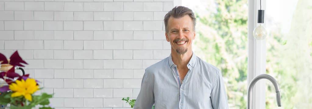 Paul Svensson hemma i sitt kök med vitt kakel granitkeramikskiva
