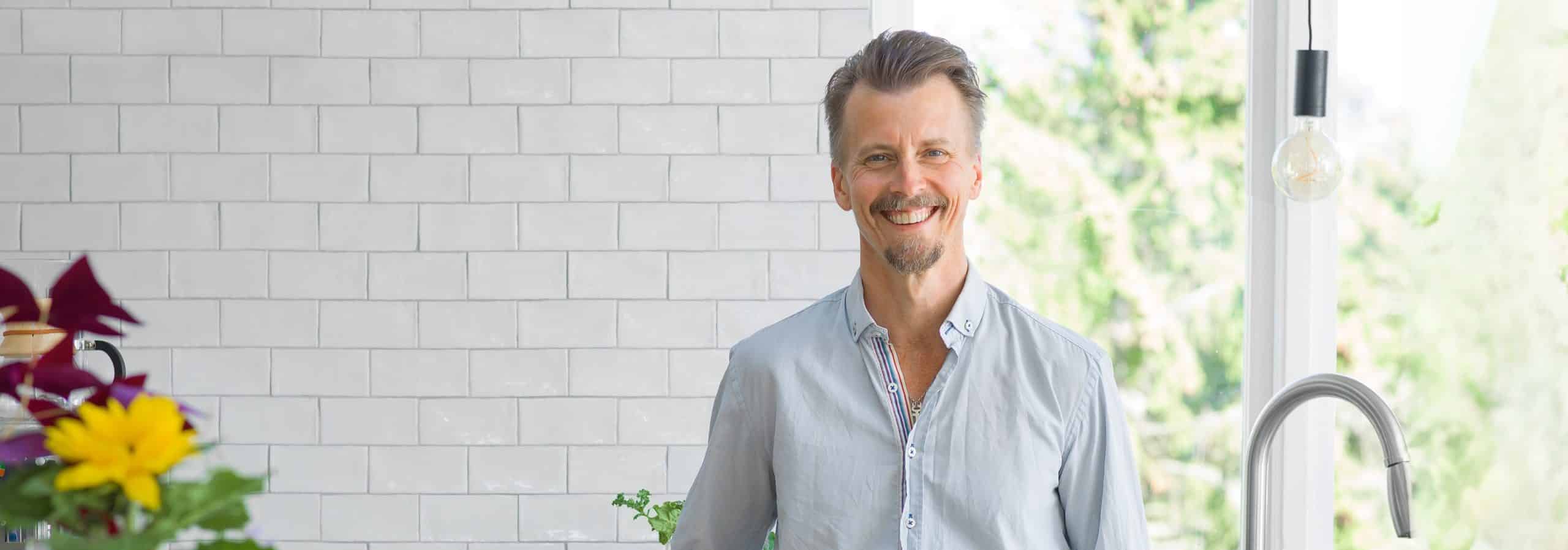 Paul Svensson hemma i sitt kök med vitt kakel granitkeramikskiva